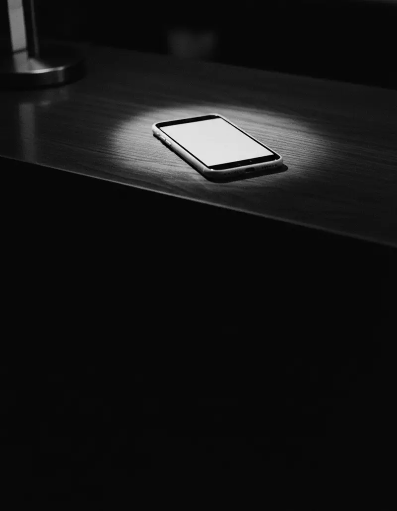 Celular aceso sobre um balcão escuro
